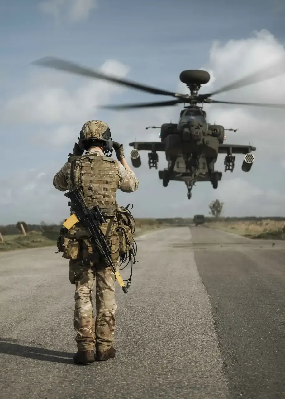 A military air traffic management process with a soldier guiding a helicopter for landing on a run way.