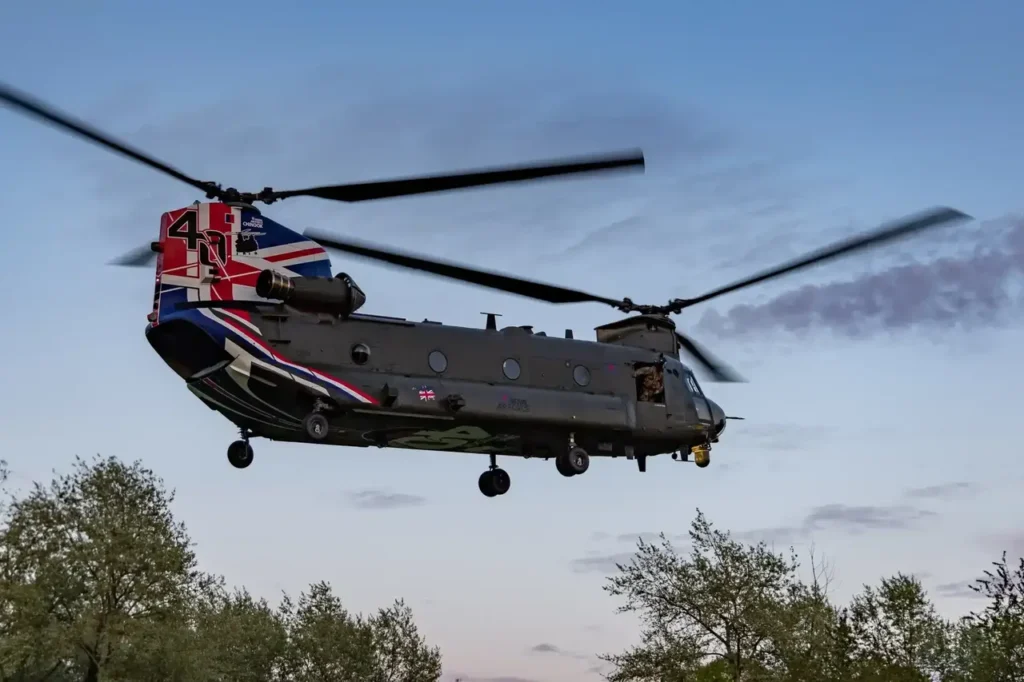 A large royal airforce chinook cruising above the trees.