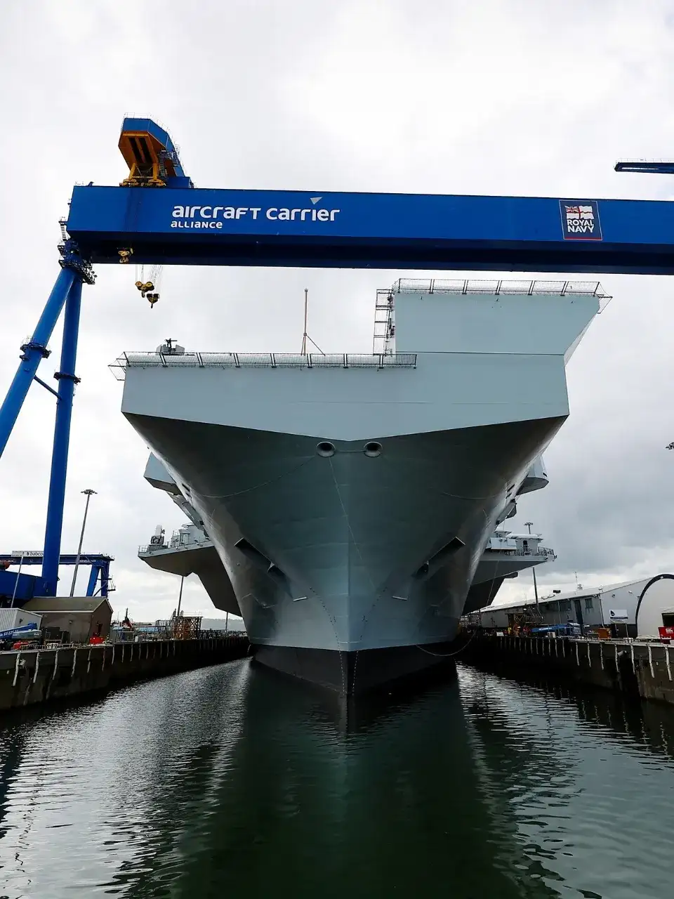 A close up of a large air craft carrier within a dock.