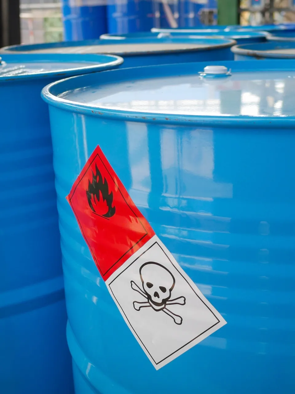 A collection of blue barrels containing high hazard substances.