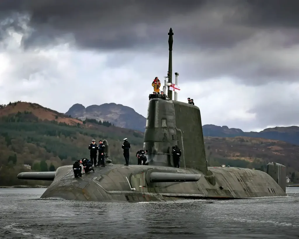 A surfaced submarine with its crew stood on its deck.