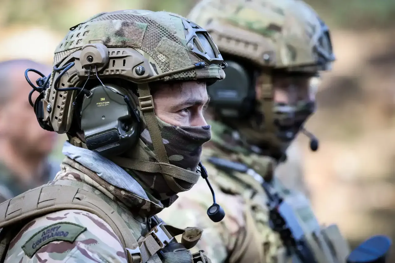 Two soldiers wearing full gear, stood facing in the same direction.